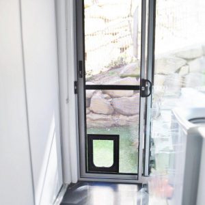 sliding crimsafe security door installed in laundry with pet door
