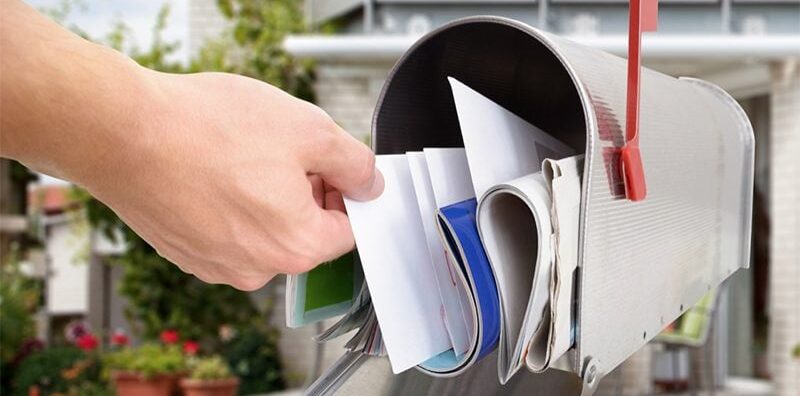 A hand getting a mail from the mailbox